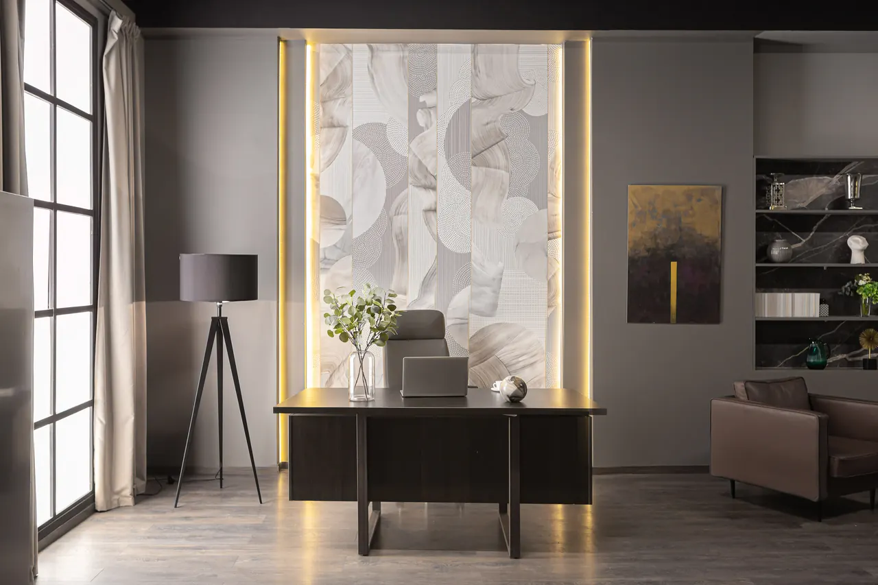 Modern home office with a desk, laptop and backlit wall panel